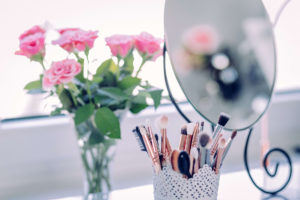 flowers makeup brush and mirror on a vanity