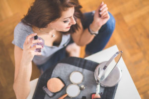woman at makeup vanity setting makeup with spray