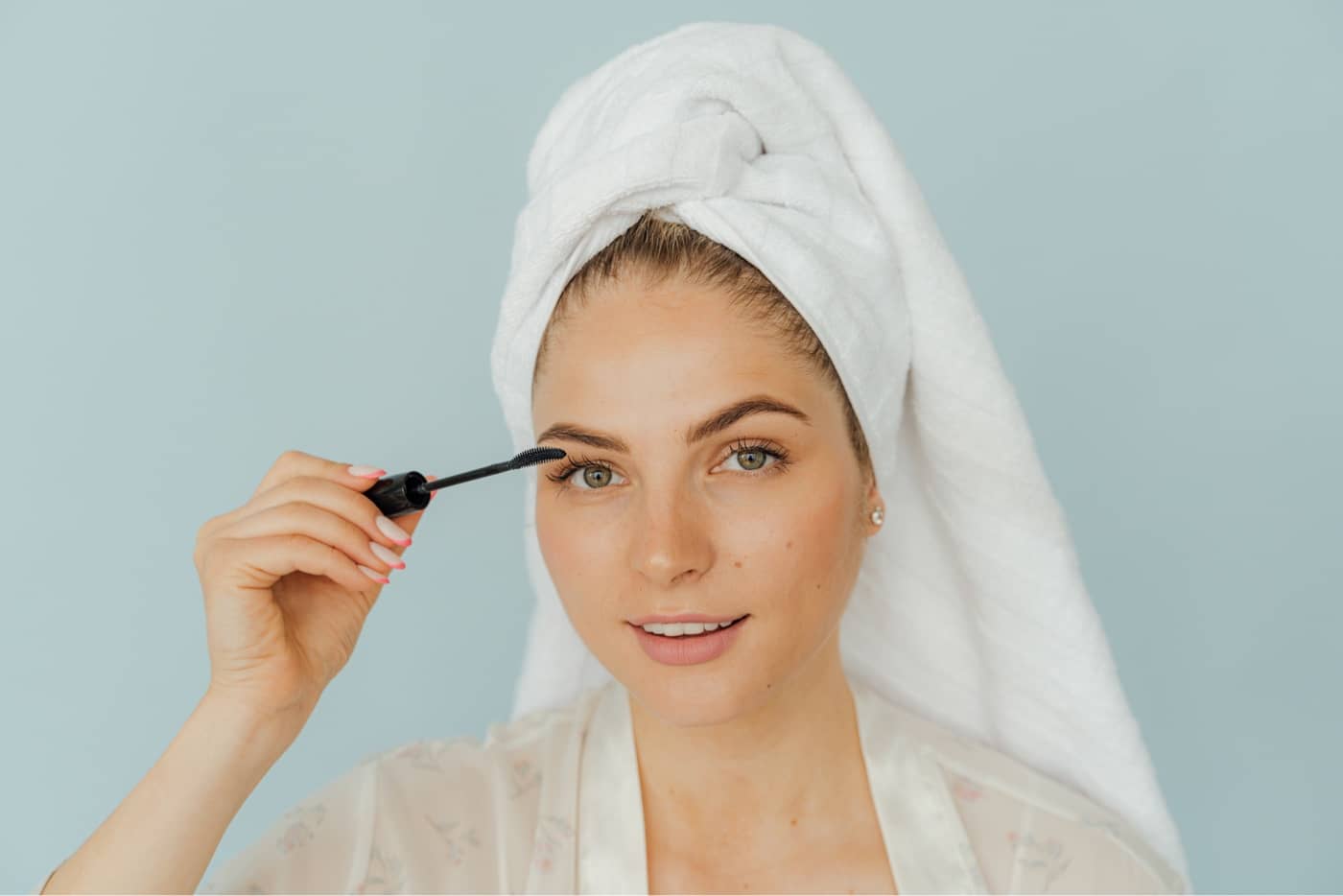 woman applying mascara with natural makeup