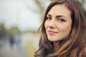 Woman with natural makeup smiling outdoors