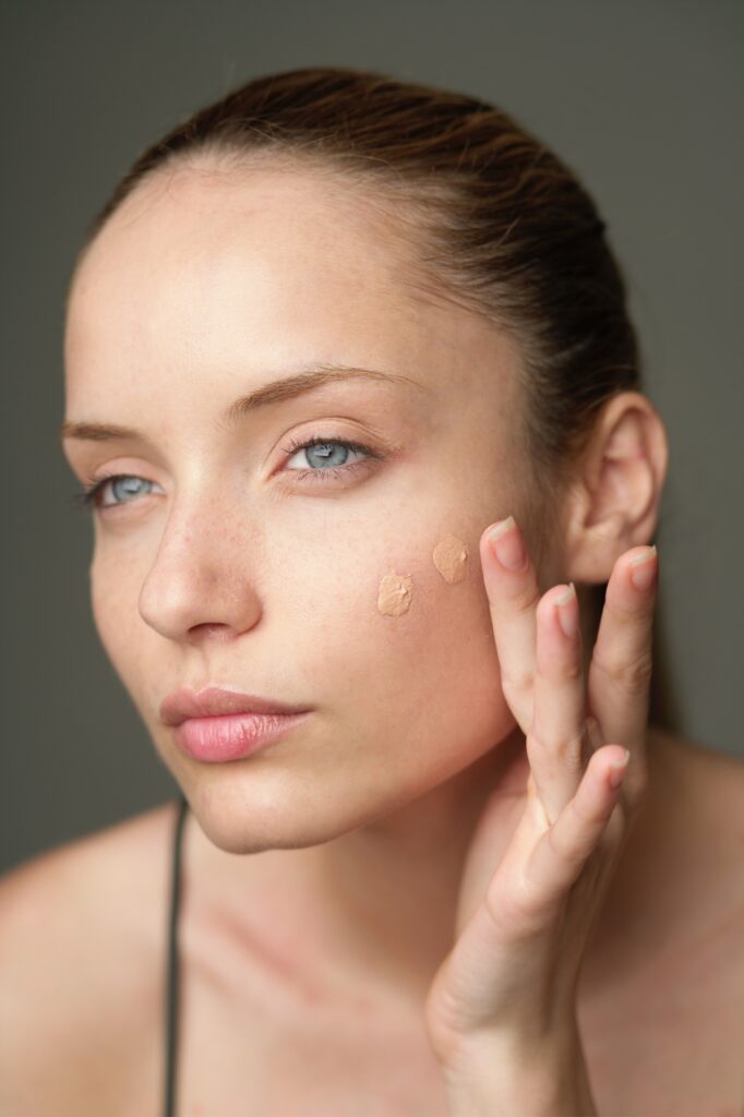 woman applying 2 dots of foundation to face