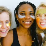 three young women doing face masks and smiling