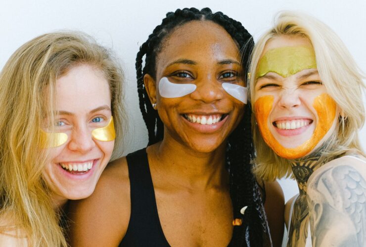 three young women doing face masks and smiling
